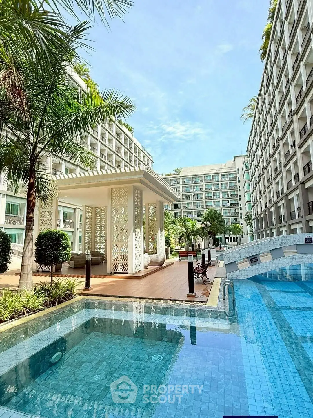 Luxurious apartment complex with stunning pool and elegant outdoor pavilion.