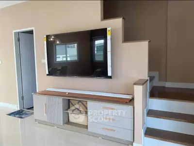 Modern living room with sleek TV unit and stylish staircase design