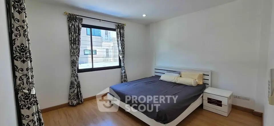 Spacious bedroom with modern decor and large window for natural light