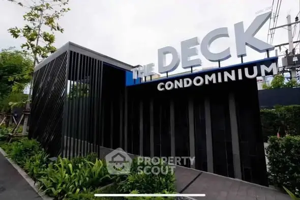 Modern condominium entrance with sleek design and lush greenery