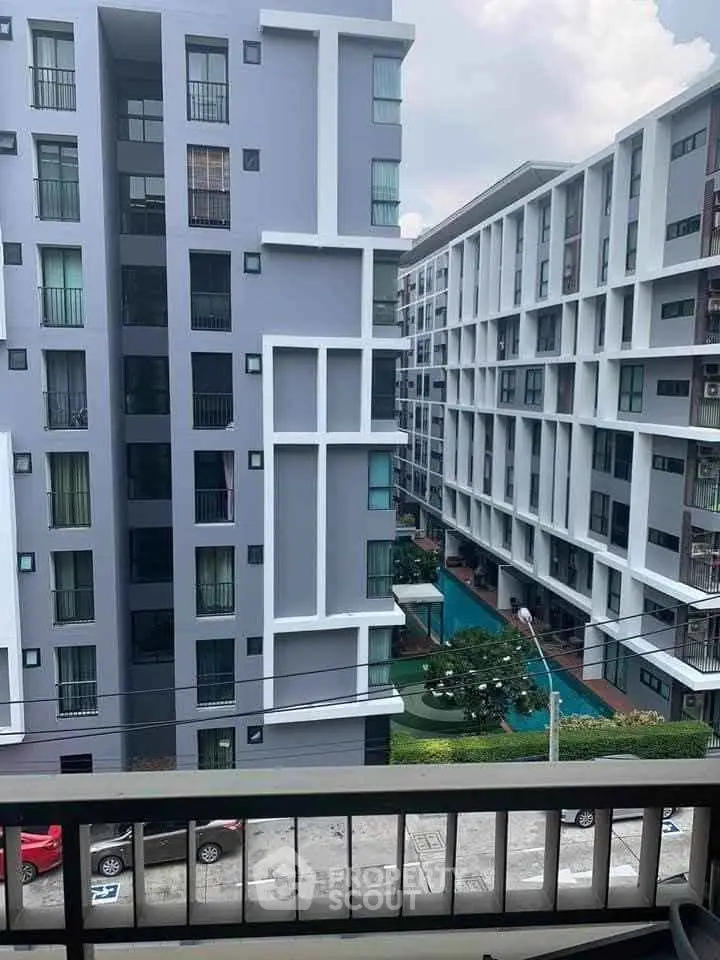 Modern apartment buildings with a view of the courtyard and pool area.