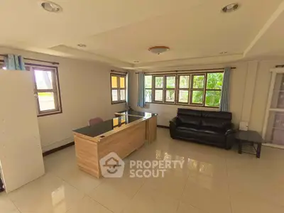 Spacious living room with modern furniture and large windows offering natural light.