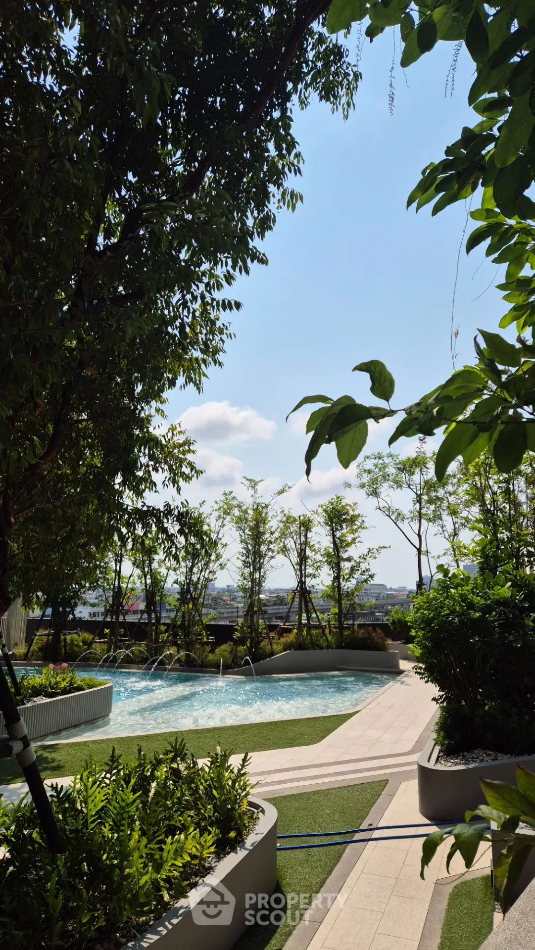 Luxurious rooftop pool with stunning city view and lush greenery