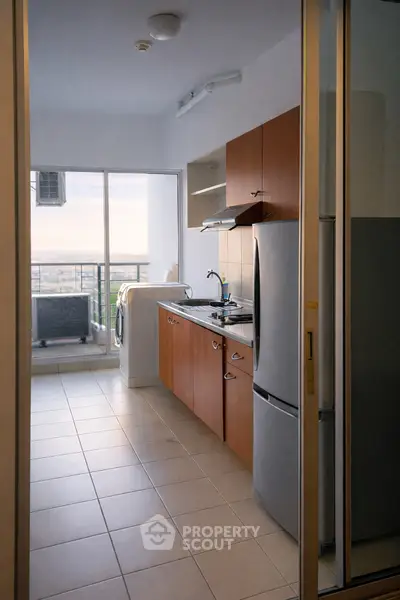 Modern kitchen with balcony view, featuring sleek appliances and ample natural light.