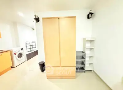 Spacious laundry area with modern washing machine and ample storage solutions.
