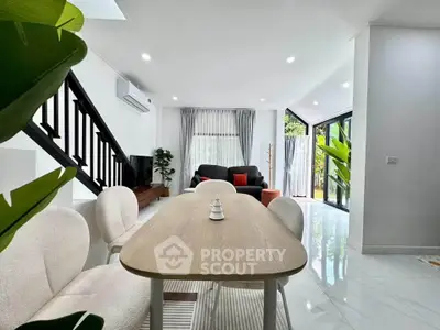 Modern open-plan living room with sleek furniture and large windows for natural light.