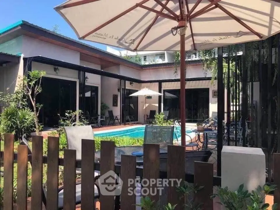 Charming backyard with pool and patio furniture, perfect for outdoor relaxation.