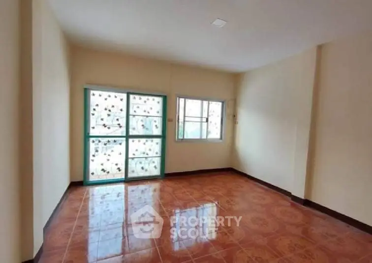Spacious empty room with tiled floor and large windows, perfect for customization.