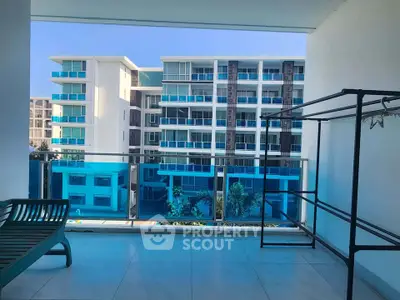 Spacious balcony with modern view of residential buildings, perfect for relaxation.