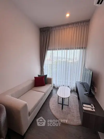 Cozy modern living room with large window and stylish furniture