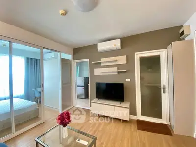 Modern living room with TV, air conditioning, and stylish decor in a cozy apartment.