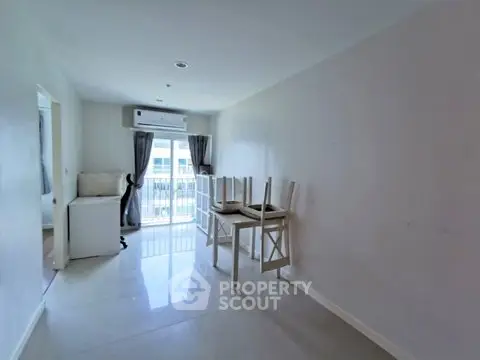 Spacious unfurnished room with large window and air conditioning, ideal for customization.