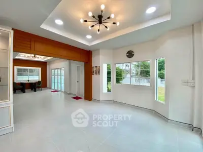 Spacious modern living room with large windows and stylish lighting in a contemporary home.