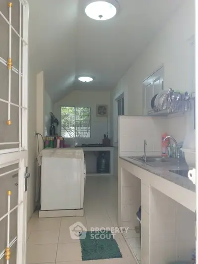 Bright kitchen with washing machine and open layout, featuring natural light and modern fixtures.