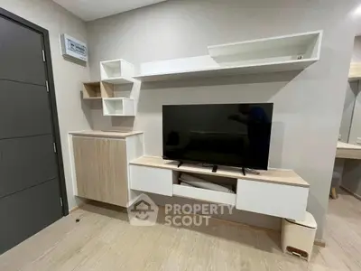 Modern living room with sleek TV unit and minimalist shelving in a stylish apartment.
