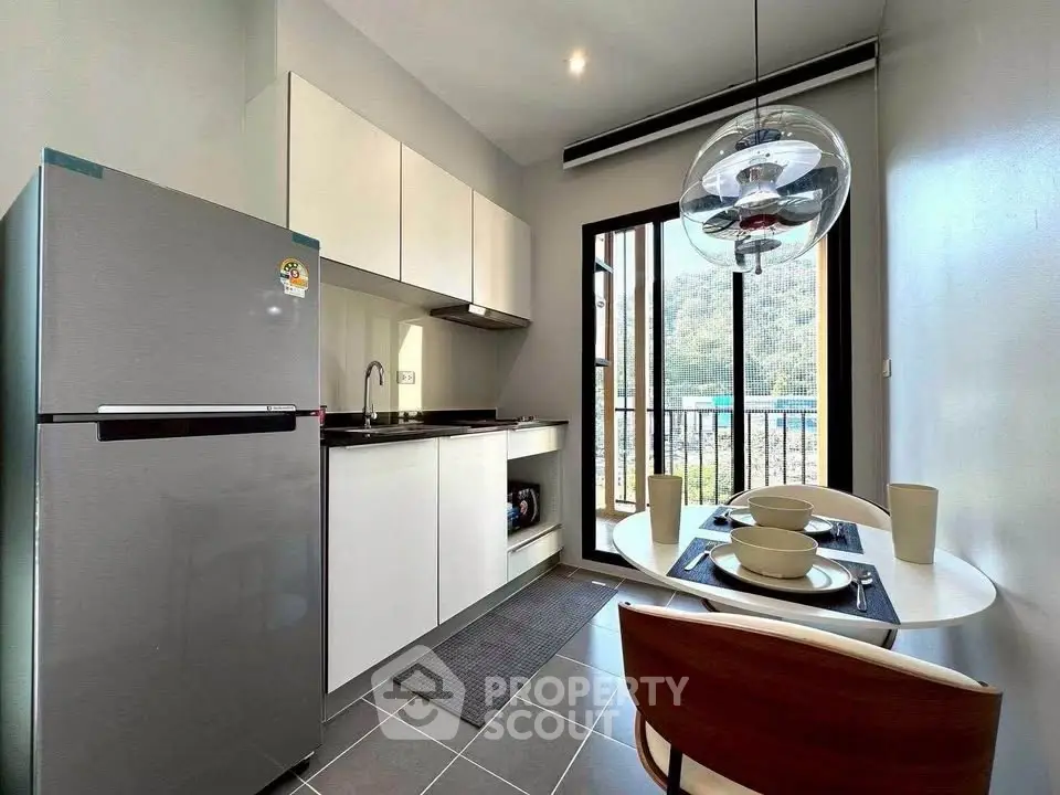 Modern kitchen with sleek appliances and dining area, featuring a large window with scenic view.
