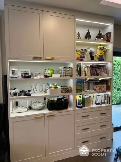 Stylish built-in shelving unit with decorative items and books in modern home interior