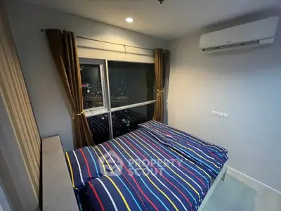 Cozy bedroom with city view, featuring modern air conditioning and stylish striped bedding.
