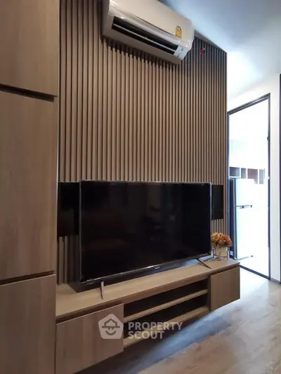 Modern living room with sleek TV setup and stylish wood paneling