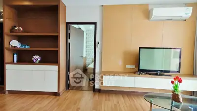 Modern living room with wooden flooring, built-in shelves, and air conditioning unit.