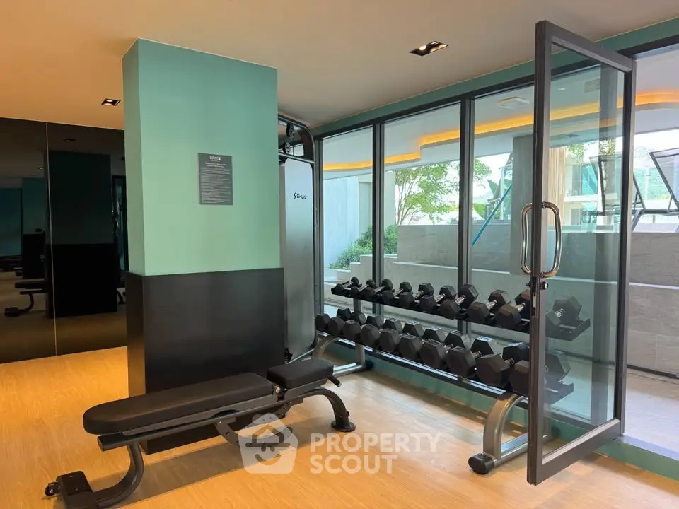 Modern gym with weights and bench in luxury residential building