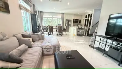 Spacious modern living room with open kitchen and elegant dining area, perfect for entertaining.