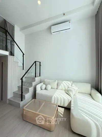 Modern living room with stylish staircase and cozy white sofa