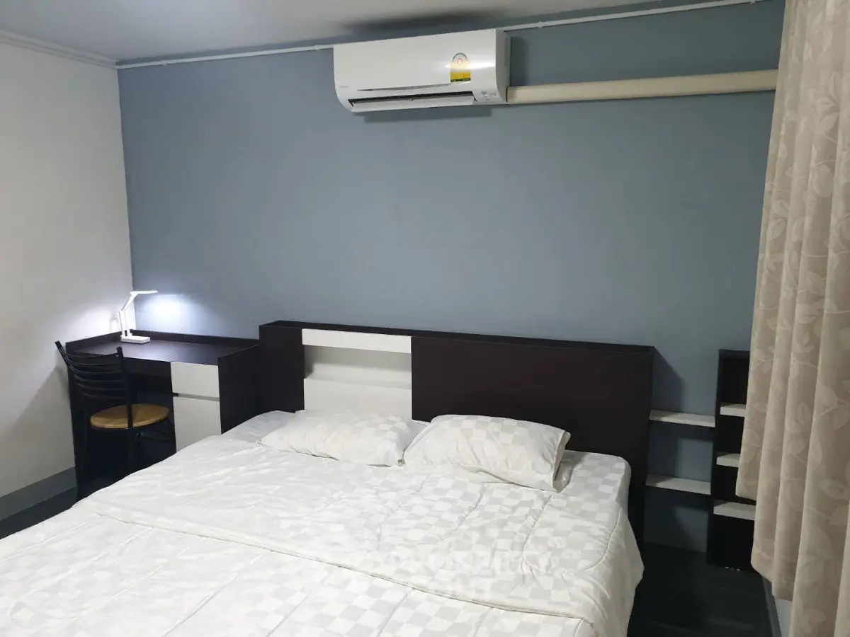 Cozy bedroom with modern air conditioning and study desk, ideal for comfort and productivity.