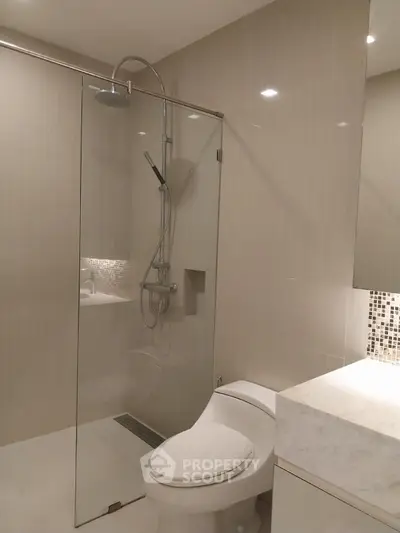Modern bathroom with glass shower and sleek fixtures in luxury apartment