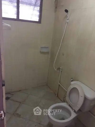 Compact bathroom with shower and toilet in a minimalist design.