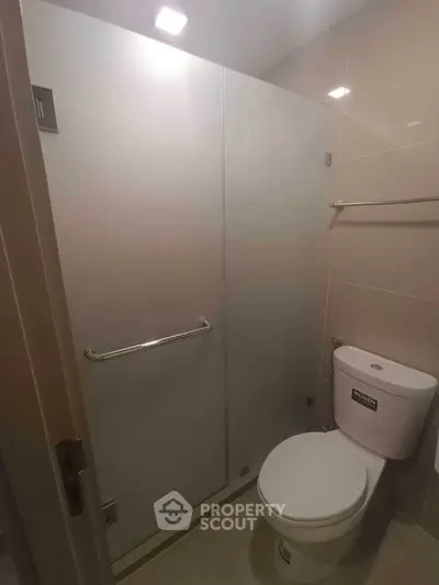 Modern bathroom with glass shower enclosure and sleek fixtures.