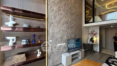 Modern living room with stylish decor and loft design, featuring a TV and elegant shelving.
