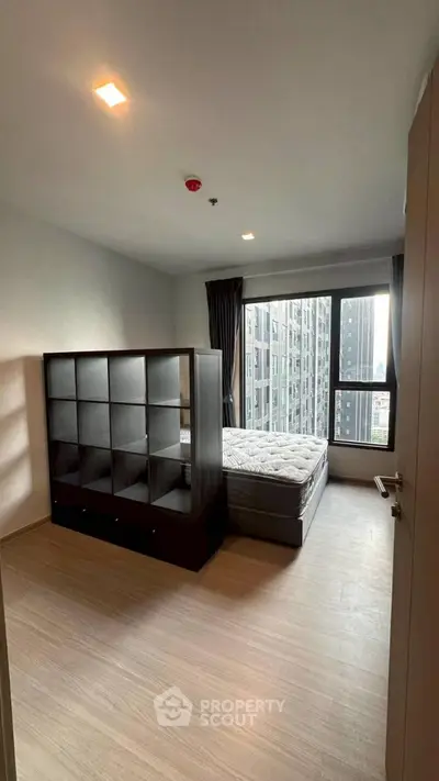 Modern bedroom with city view, featuring a stylish partition and large windows.