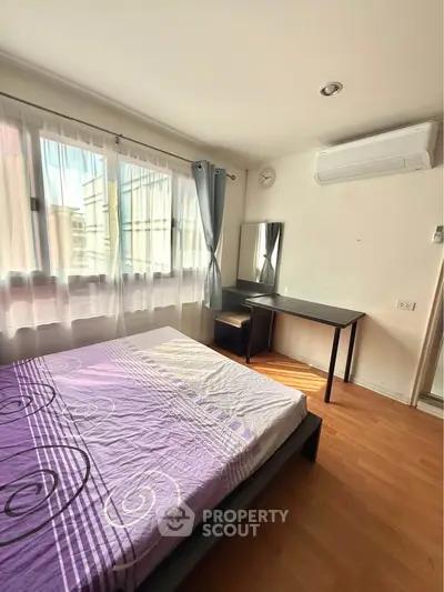 Bright bedroom with large window, air conditioning, and modern furniture.