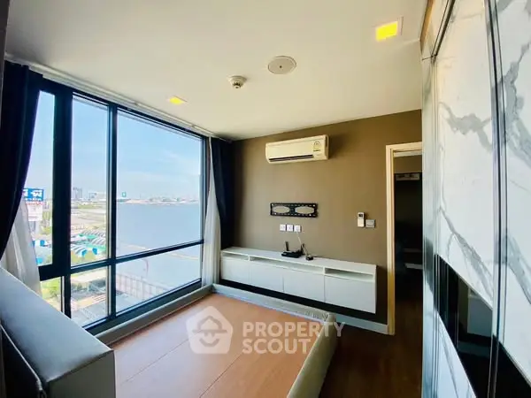 Modern bedroom with large windows offering stunning river view