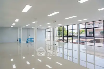 Spacious open-plan commercial space with large windows and natural light