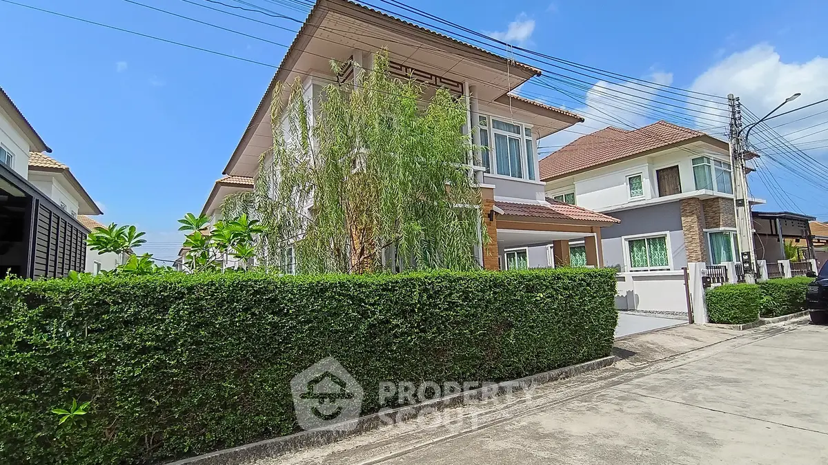Charming suburban house with lush greenery and modern architecture under a clear blue sky.