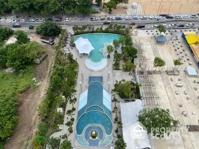 Stunning aerial view of luxurious pool area with lush greenery and modern design, perfect for relaxation.