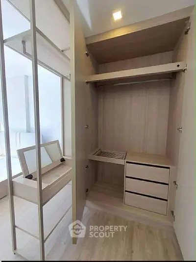 Spacious modern wardrobe with built-in drawers and shelves in a stylish bedroom setting.