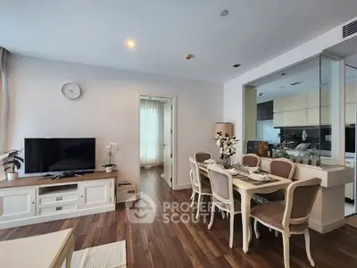 Elegant living room with dining area and modern kitchen in open layout apartment.