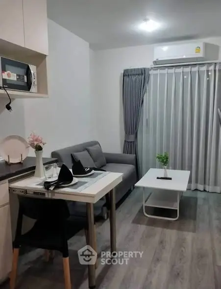 Modern living room with cozy sofa, dining table, and air conditioning in a stylish apartment.