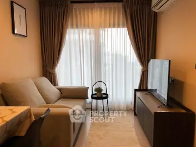 Cozy living room with modern sofa, TV, and elegant curtains, perfect for relaxation.