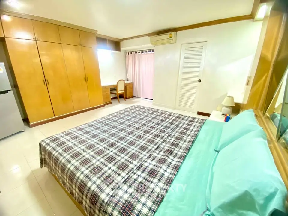 Spacious bedroom with built-in wardrobe and natural light in modern apartment