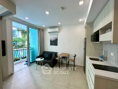 Modern open-plan living room with kitchen, balcony view, and stylish decor.