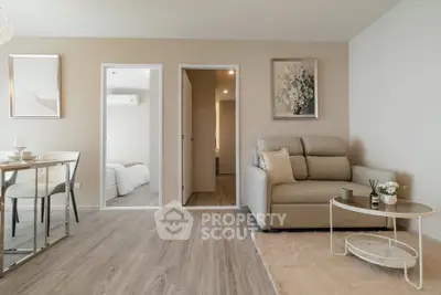 Modern living room with cozy sofa, elegant decor, and open layout leading to bedroom.