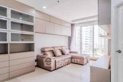 Modern living room with sleek furniture and large windows offering city views.