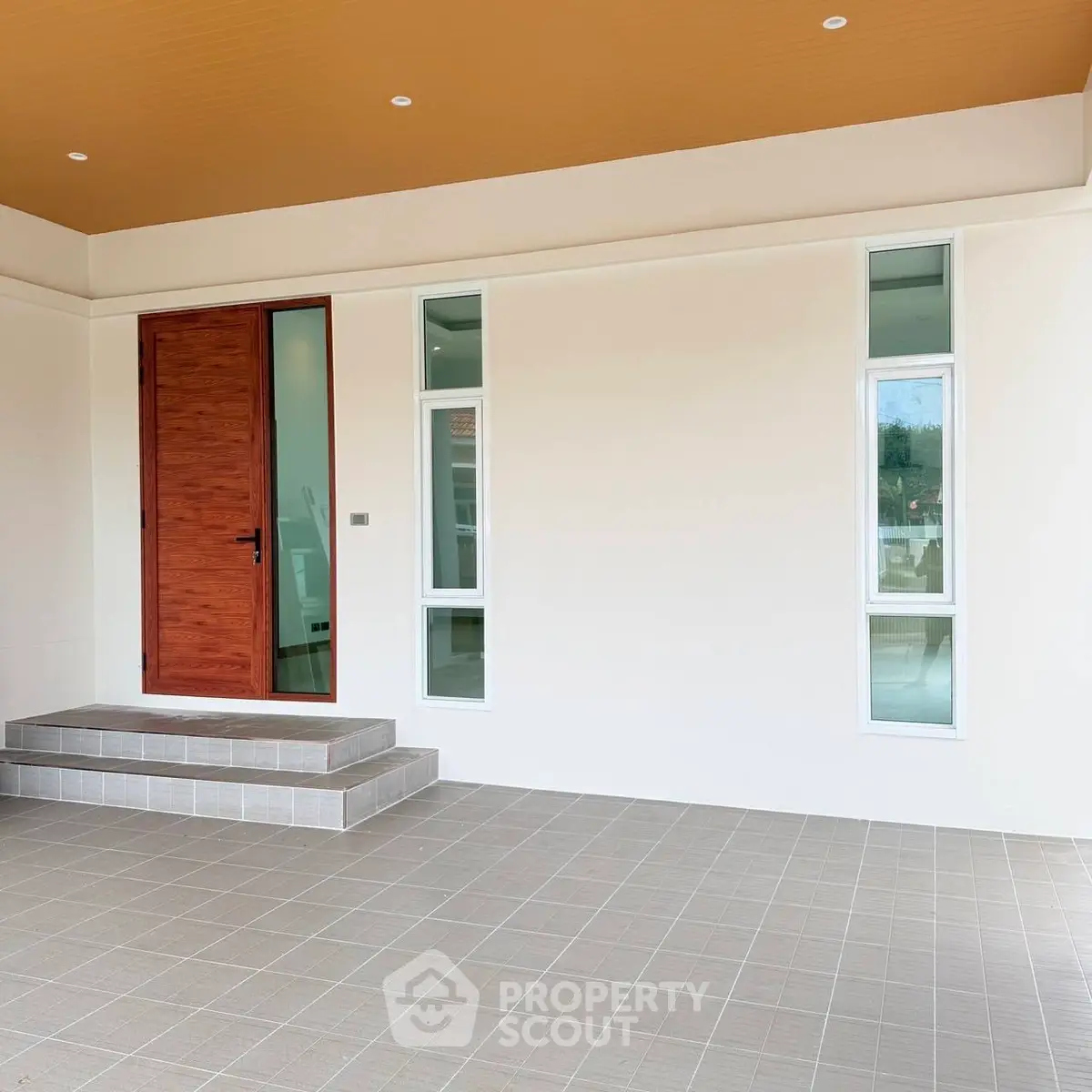Modern entrance with wooden door and tiled steps in a contemporary home