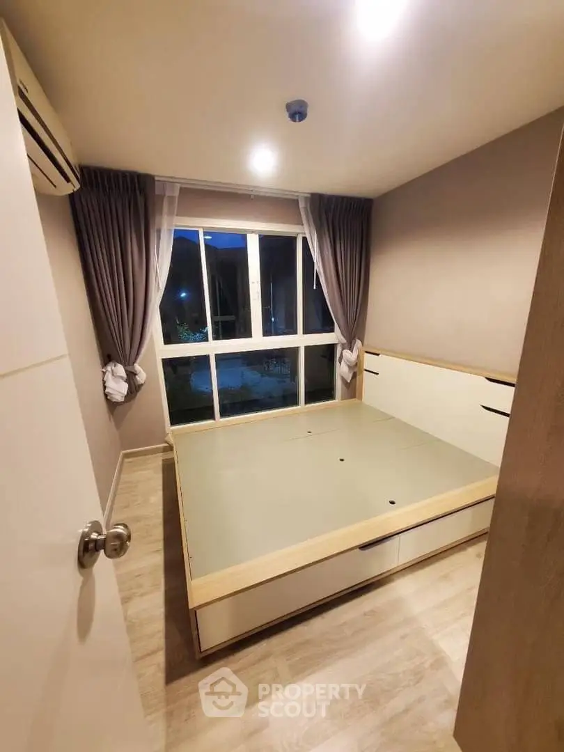 Cozy bedroom with large window and modern design in a stylish apartment.