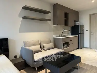 Modern living room with sleek kitchen and stylish furniture in open layout apartment.
