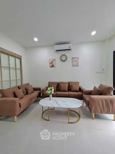 Stylish living room with modern brown sofas and elegant marble coffee table.